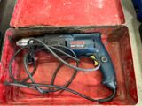 a small electric drill in a red box on a table