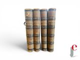 several old books stacked on top of each other on a white surface