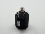 une bouteille noire avec une étiquette, posée sur une table