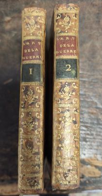deux vieux livres posés l'un à côté de l'autre sur une table en bois