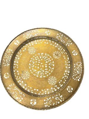 a gold plate with a design on it on a white background