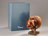 a sculpture of a snail on a stand next to a box