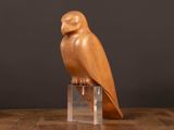 une image représentant un hibou en bois posé sur une table en bois