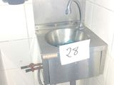 a metal sink in the corner of a bathroom