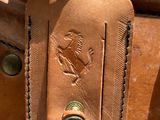 a close up of a brown leather bag with a tag on it