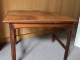 une image représentant une table en bois posée sur un sol recouvert de moquette
