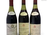 three bottles of wine are lined up on a white surface