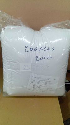 un oreiller blanc posé sur une boîte en carton posée sur une table