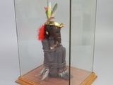 a glass display case with a statue of a person wearing a headdress