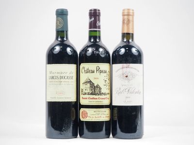 trois bouteilles de vin posées les unes à côté des autres sur une surface blanche