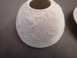 a white vase sitting on a table next to a plate