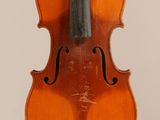 an old violin sitting on top of a white surface