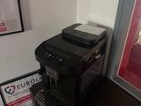 a coffee machine sitting on top of a table next to a poster