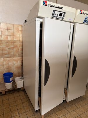 trois réfrigérateurs blancs dans une pièce aux murs carrelés