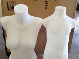 two white mannequins sitting on a cardboard box