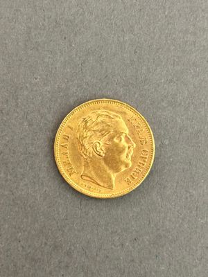 a close up of a gold coin on a gray surface