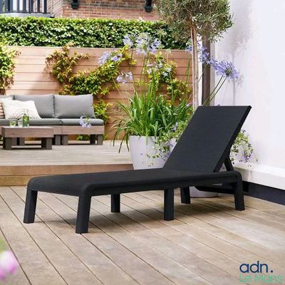 a black chaise lounger on a wooden deck