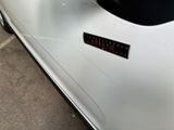 a close up of a white car with a sticker on it