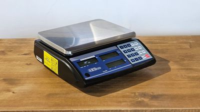 un gros plan d'une balance numérique posée sur une table en bois
