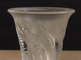 a clear glass vase sitting on a table with a black background