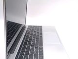 a silver laptop with a black keyboard on a white surface