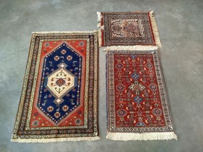 trois tapis orientaux posés sur le sol d'une pièce