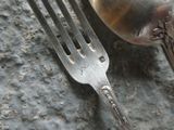 a fork and a spoon sitting on a rock