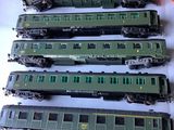 several green trains are lined up on a white surface