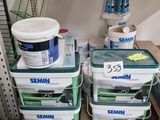 several buckets of paint are stacked on top of each other