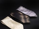 trois cravates de couleurs différentes posées les unes à côté des autres sur une surface noire