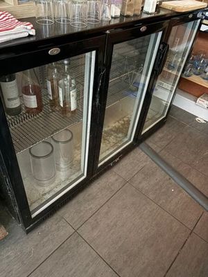 une vitrine sur laquelle sont posées de nombreuses bouteilles