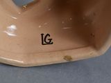 a close up of a brown vase with a black g on it