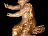 a gold statue of a child on a black background