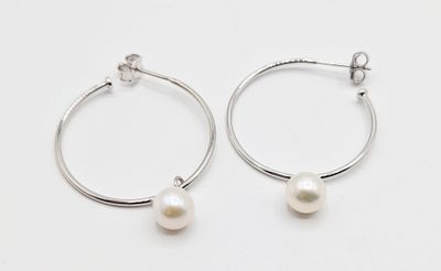 boucles d'oreilles en anneau en argent ornées de perles blanches, posées sur un fond blanc