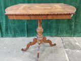 an old wooden table with a wooden top on a stone floor