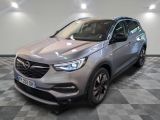 un SUV Opel gris garé dans une grande pièce au sol carrelé
