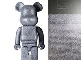 un ours en argent posé à côté d'un livre