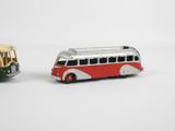 two toy buses that are next to each other on a white surface