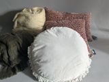 three pillows and a blanket on a white surface