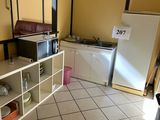 une petite cuisine équipée d'un micro-ondes et d'un réfrigérateur