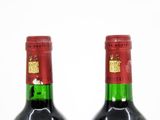 two bottles of wine sitting next to each other on a table