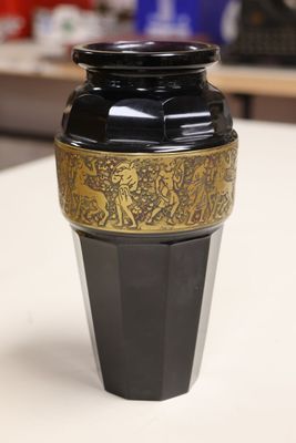 a black and gold vase sitting on a white table