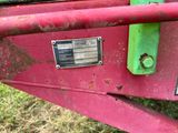 un gros plan d'un tracteur rouge sur lequel est accrochée une pancarte