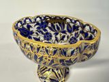 a blue and gold bowl sitting on a white surface