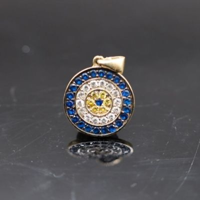 une image représentant un pendentif « œil maléfique » en diamant et saphir sur un fond noir