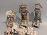 trois figurines en céramique représentant des Amérindiens et un bébé allongé par terre