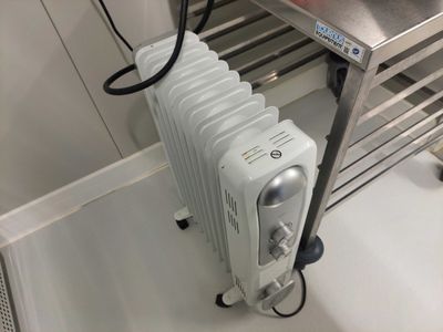 un radiateur posé au sol à côté d'un lavabo