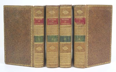 three old books sitting on top of each other on a white surface