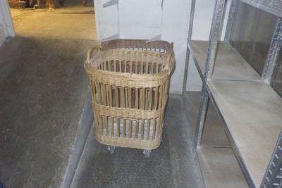 un panier en osier posé par terre dans un coin de la pièce