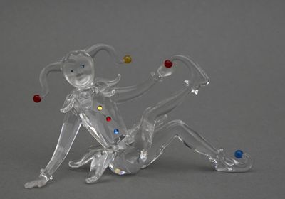 une figurine en verre représentant une femme assise par terre